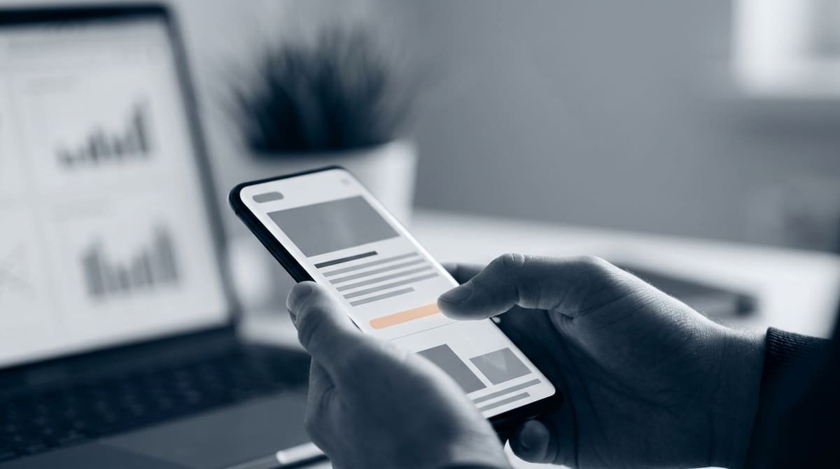 Foco em mãos segurando um smartphone moderno enquanto navegam de forma rápida e fluida por uma página da web.