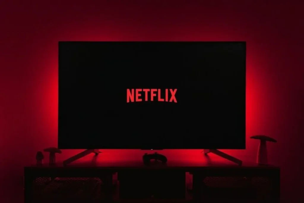 tela com logotipo da Netflix exibido em ambiente escuro, representando plataforma de streaming e modelo de negócio digital